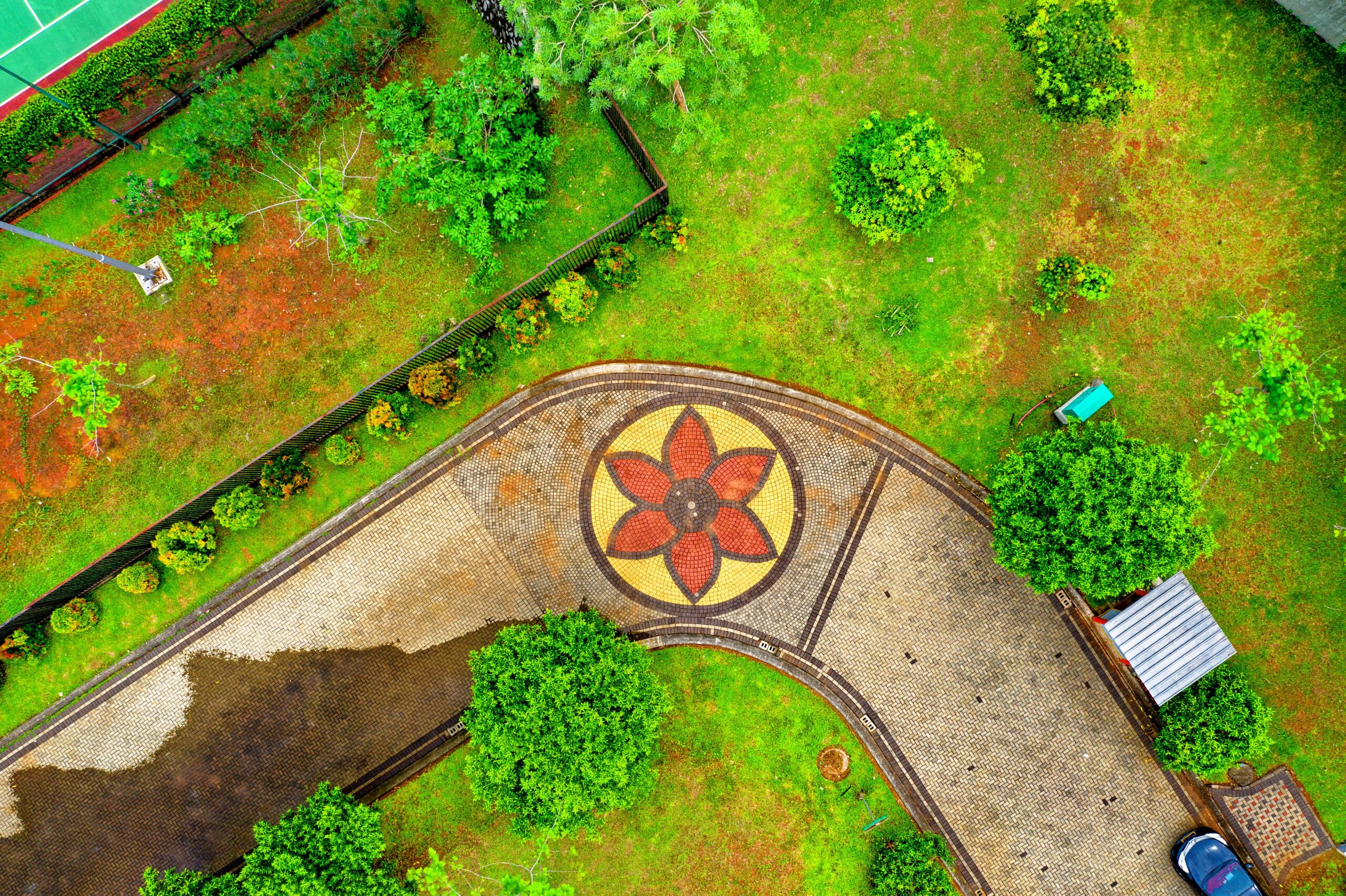 Colorful aerial view of a landscaped garden pathway with intricate floral mosaic design in Sindang Jaya, Banten, Indonesia.